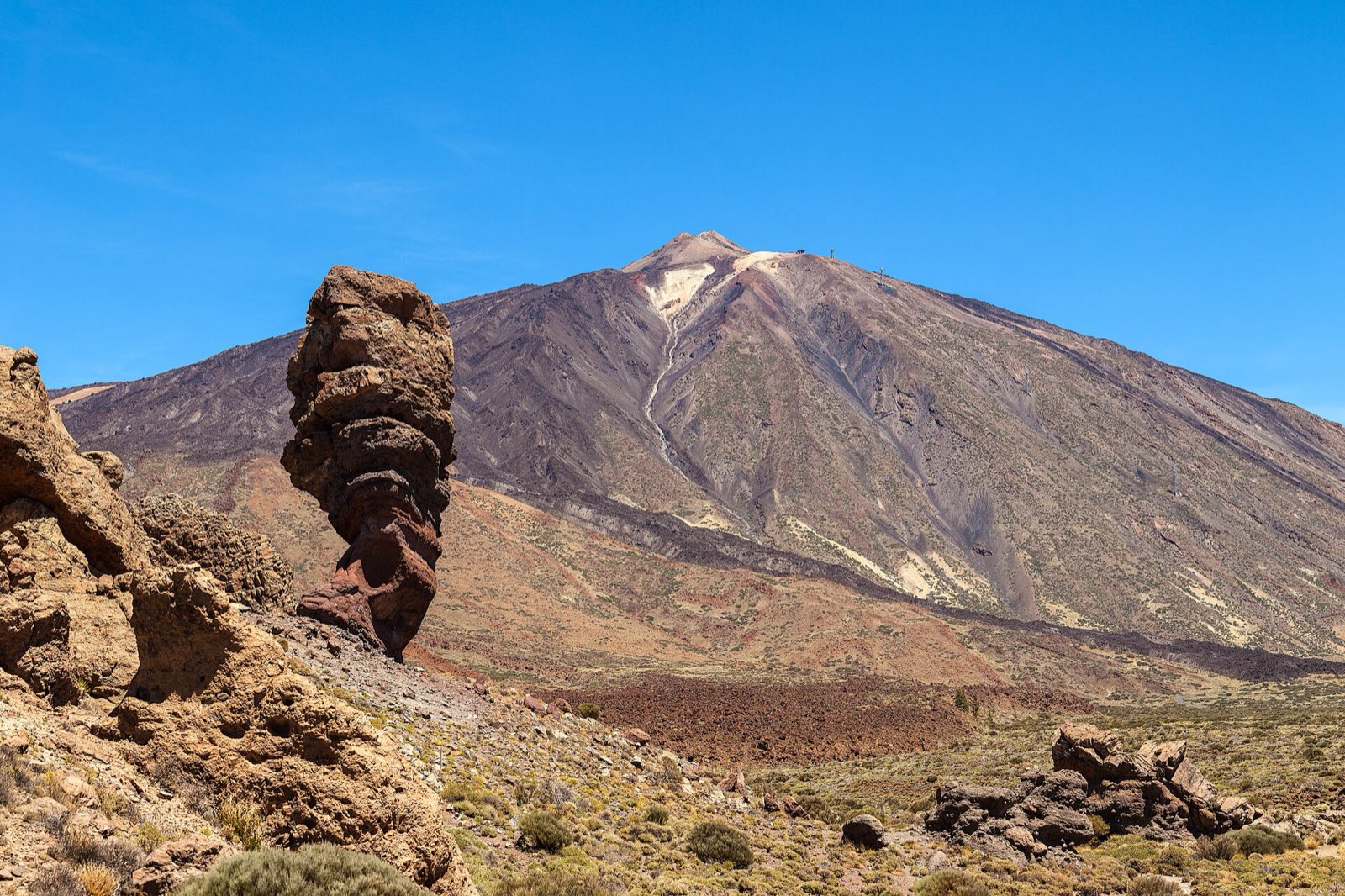 The Roque Cinchado rock tower in front of Mount Teide under a clear blue sky, Teide National Park, Tenerife