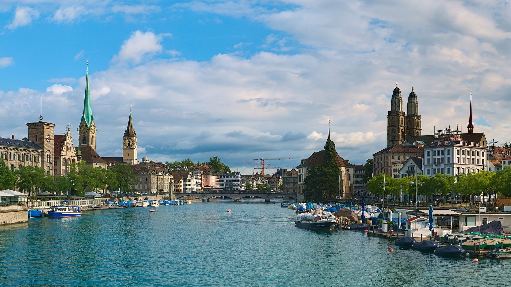View down the Limmat from the Quaibrücke in Zurich, with the spires of the Fraumünster and St Peter on the left bank and the twin towers of the Grossmünster on the right