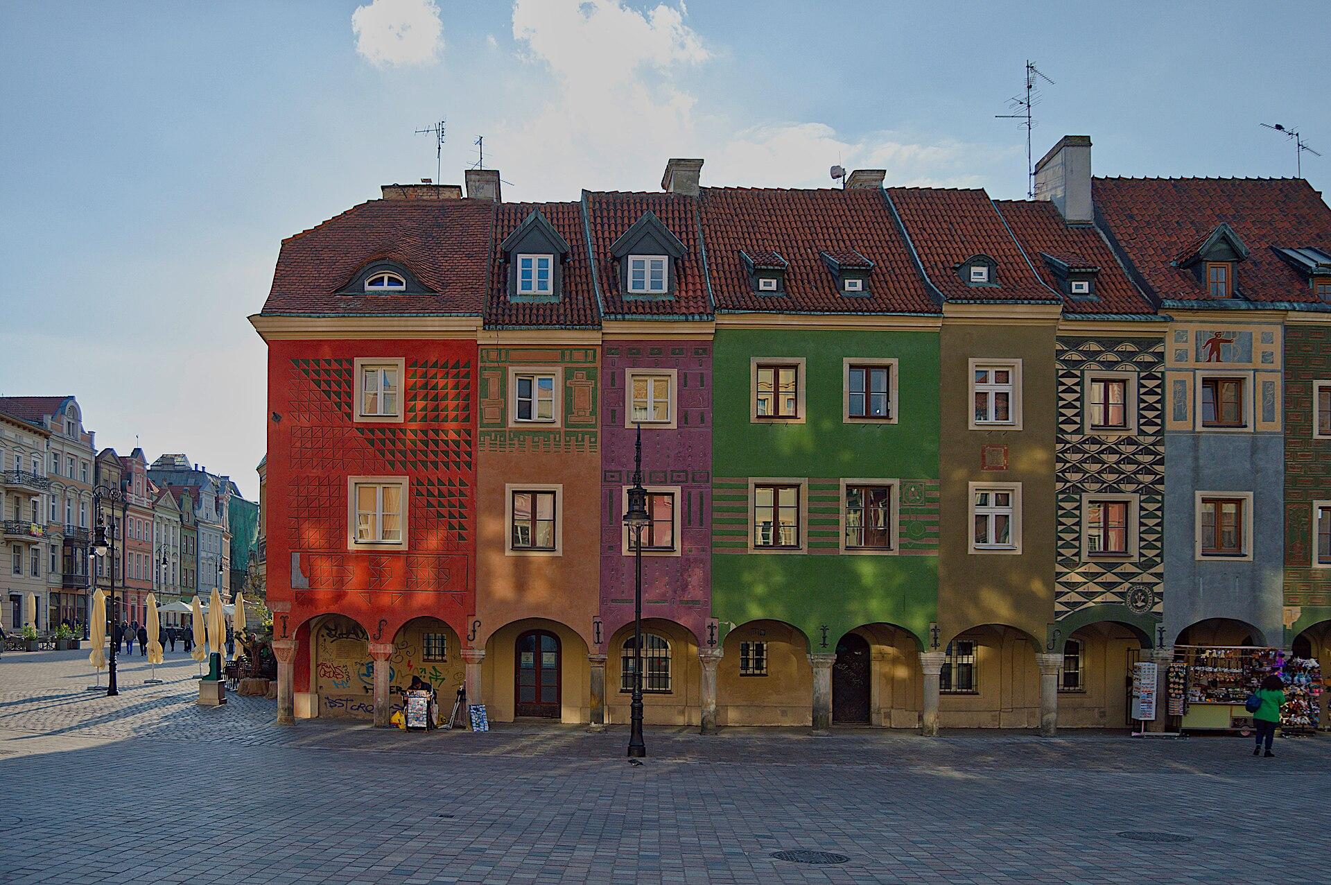 Row of narrow, brightly painted merchants’ houses with arcades and red tiled roofs on the Old Market Square in Poznań